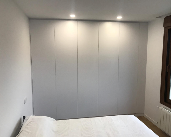 Vestidor de puertas blancas del tamaño de una pared